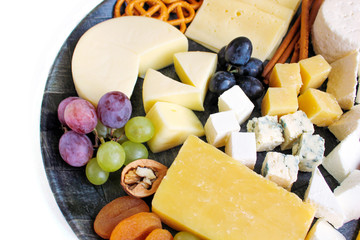 Rustic cheese platter with different cheese and grapes