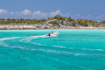 Bahamas, Exuma Island, Cays Land and Sea Park. Man and dog in skiff. Credit as: Don Paulson / Jaynes Gallery / DanitaDelimont.com