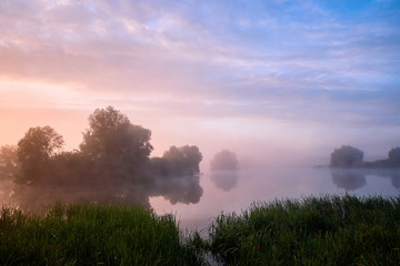 Foggy morning. Dawn outside the city. It will be a warm day. Morning fog on the lake