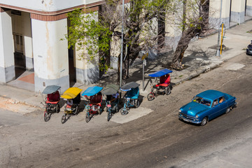 Cuba. Havana. Classic car and pedicab.
