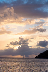 Naklejka na ściany i meble UK, British Virgin Islands. Sailboat and rain on horizon at sunset