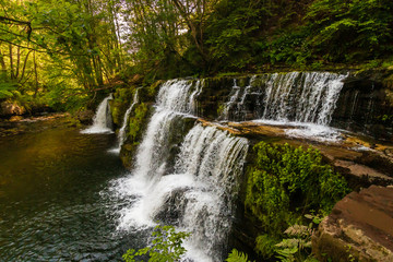 A scenic waterfall surrounded by forest in South Wales (Sgwd y Pannwr, Waterfall country, Wales)