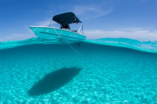A boat is anchored in the clear blue tropical waters off Staniel Cay, Exuma, Bahamas