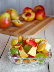 Healthy fruit salad and slices of fruits on a cutting board,making of fruit salad