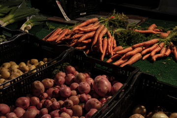 Fresh carrots & red potatoes layed out by farmers in the market. 