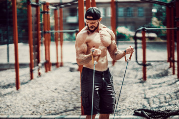 Fitness man exercising with stretching band. Muscular sports man exercising with elastic rubber band. Guy working out with rubber band. Fit, fitness, exercise, workout and healthy lifestyle