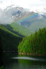 Fototapeta na wymiar Canada: British Columbia, rainbow between Cache Creek (tribuaty into Lake Revelstoke, part of Columbia river) and Mount Iconoclast