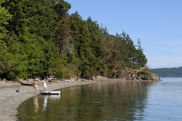 Canada, British Columbia, Gulf Islands, Portland Island. People getting out of a dinghy at the beach in Princess Bay