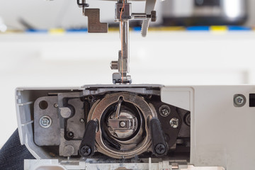 sewing machine with colour thread and needle on a table with blurred background, Tailor's work table, textile or fine cloth making, industrial fabric, home appliances tool.