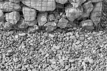 Wire Mesh Cage With Natural Rocks and Stones Inside on Coast with Pebbles. It's a Stylish Structure for Support Pictures and Photos at Open Air Art Gallery on Brighton Beach. Copy Space. Gray Color.