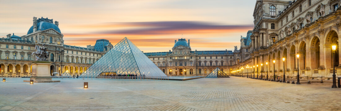 View of famous Louvre Museum with Louvre Pyramid at evening