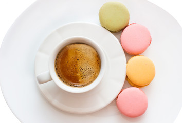 Macarons with a coffee cup isolated on white background, Good morning or have a nice day message concept, white cup of espresso coffee with colourful french macarons, Top view.