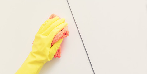 Human in protective gloves cleaning kitchen cabinet, human hands, close up, copy space, toned