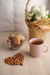 cup of tea with almonds and cookies