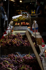 Red and orange fruits & vegetables laid out on display in bunches at a local farmers market.