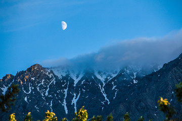 Canada, Yukon Territory, Destruction Bay, Kluane National Park and Reserve. Moonrise over Kluane Mountain shrouded with clouds
