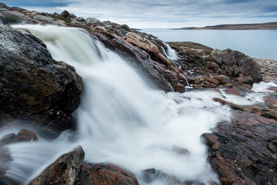 Canada, Nunavut, Territory, Blurred image of rushing river near Cape Cleveland along Hudson Bay near Arctic Circle