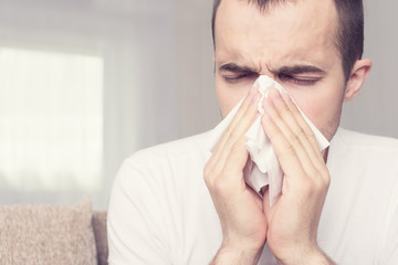 Handsome male, blew his nose, blocked nose, a man is at home on sick leave, portrait, close up,...