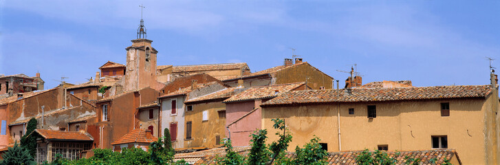 Fototapeta na wymiar France, Roussillon. The tones of Roussillon buildings-amber, terra cotta and peach-provide a lovely contrast to the calm blue sky, in Provence, France.