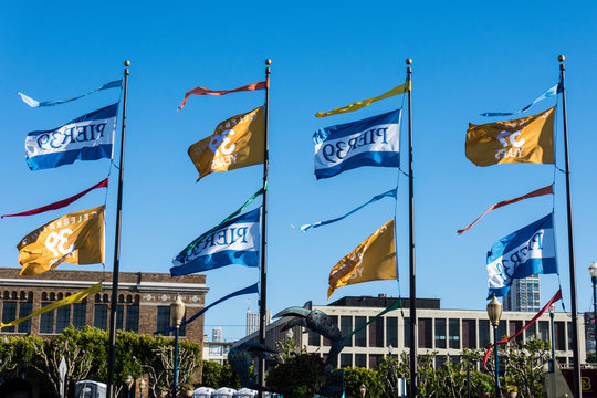 JULY 6 2017 - SAN FRANCISCO, CALIFORNIA: Flags celebrating Pier 39's 39th anniversary fly against a blue sky.