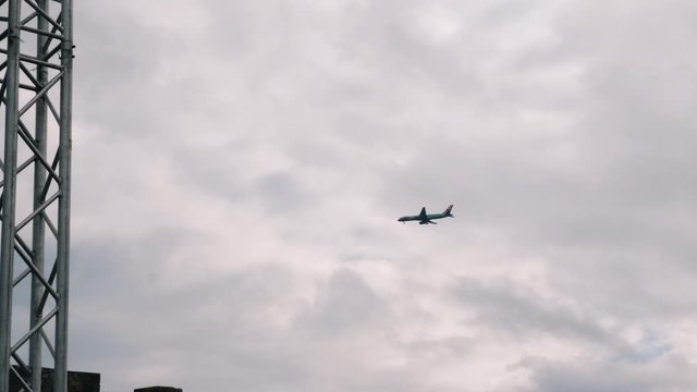 Airplane flying in sky. Plane lands at airport. Airplane going to landing. Blue airplane in sky. Jet flies in sky. Aircraft landing at Cyprus island. Passenger jet against grey sky