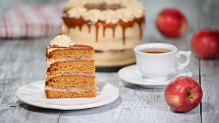Plate with piece of delicious caramel apple cake on table