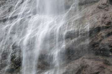 Fototapeta na wymiar Water stream falls from mountain, rock's waterfall