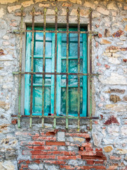 Fototapeta na wymiar Italy, Tuscany. Turquoise window on brick building.