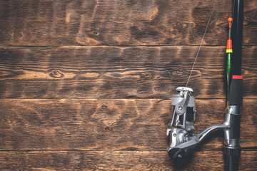 Fishing rod on a wooden table. Fishing flat lay background with a copy space.