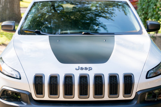 Front detail hood grill of a white Jeep Cherokee Trailhawk SUV vehicle