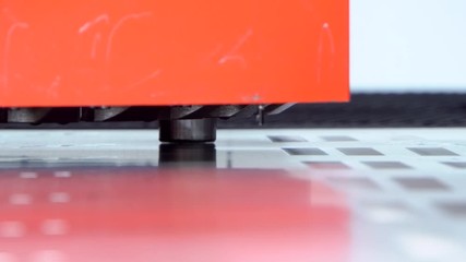 Rotation CNC punching & nibbling machine in action. Metal perforating industrial machine