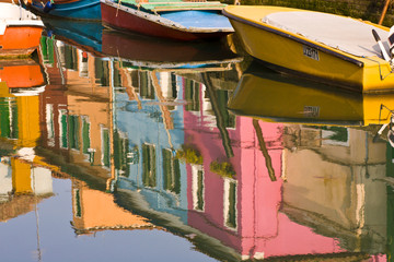 Fototapeta na wymiar Italy, Burano. Boats on a canal with reflections of colorful houses on the water. Credit as: Wendy Kaveney/ Jaynes Gallery/ DanitaDelimont.com