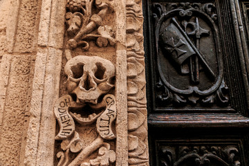 Italy, Bari, Apulia, Monopoli. Roman Catholic church entrance. Door and arch detail. Skull. Latin reads 'hodie mihi cras tibi', 'Today me, tomorrow you. '