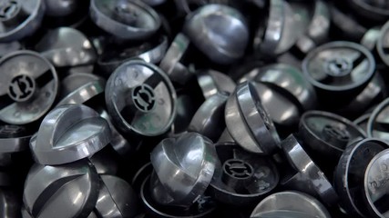 A large number of small white plastic parts in the factory.