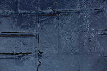 Pedestrian road paved with stones under the rain