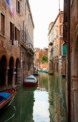 Fototapeta na wymiar Venice, Veneto, Italy - Buildings surrounded by the canals in Venice, Italy. Boats are parked in the canals.