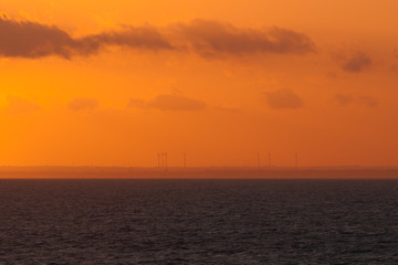 Wind turbines on italian coast at sunset