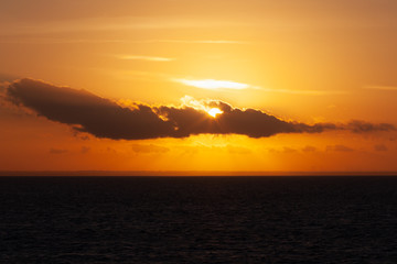 Sun rising in the clouds during sunset on the Adriatic coast