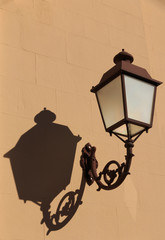 Italy, Pienza. Wrought iron street light mounted on a wall.