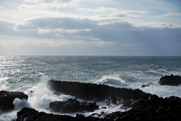 Italy, Sicily, the Ionian sea coast at Stazzo, Aci Reale, Catania. Black lava stones.