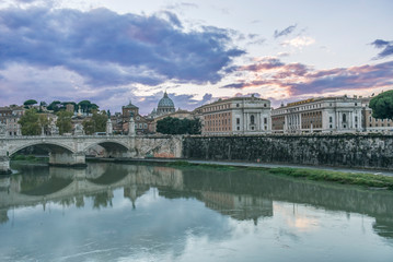 Fototapeta na wymiar Italy, Rome, Tiber River and Ponte Vittorio Emanuele with St. Peter's Basilica in the Background at Sunset