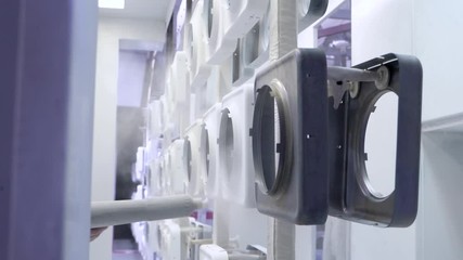 Man paints metal products from a spray gun, white paint. Close up