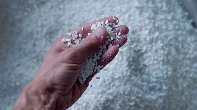 Plastic granules are poured from the hand. Plastic granules, dye, polymer granules are used for the production of plastic products