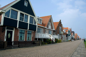 The Netherlands (aka Holland), Volendam. Popular picturesque fishing village on the IJsselmeer. Typical homes along dike.