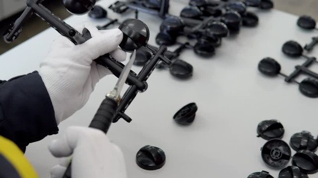 man in white gloves, ready cut plastic handle whirlings after stamping