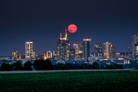 Vollmond &uuml;ber der beleuchteten Skyline von Frankfurt am Main in Deutschland