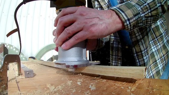 Man Uses Construction Router to Cut Notch in Lumber