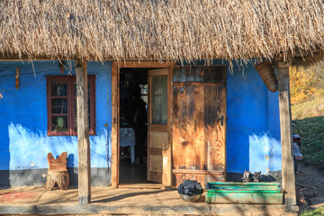 Romania, Maramures County, Dobricu Lapusului. Typical farm house, blue color.