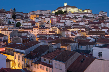 Fototapeta premium Portugal, Coimbra. Hillside view of houses and the University of Coimbra neighborhood, at sunset into the evening.
