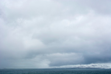 Norway. Svalbard. Hornsund. Heavy clouds over the calm water.